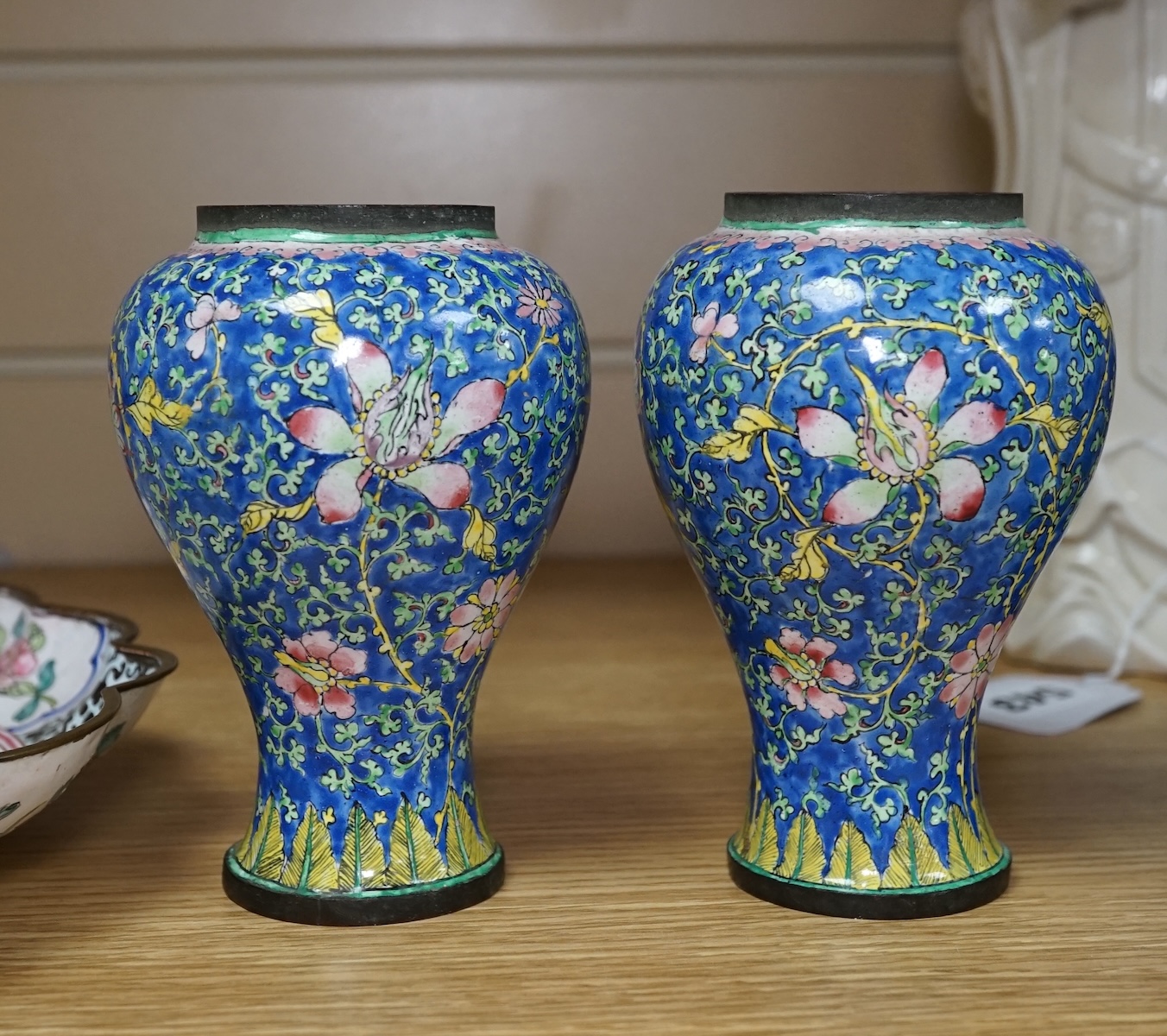 A pair of Chinese Guangzhou enamel vases, 19th century and an 18th century Guangzhou enamel dish, largest 26cm in diameter (3). Condition - fair